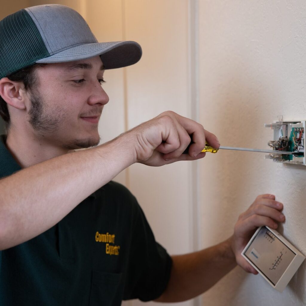 AC Genius HVAC technician checking a thermostat at a Colleyville, TX home